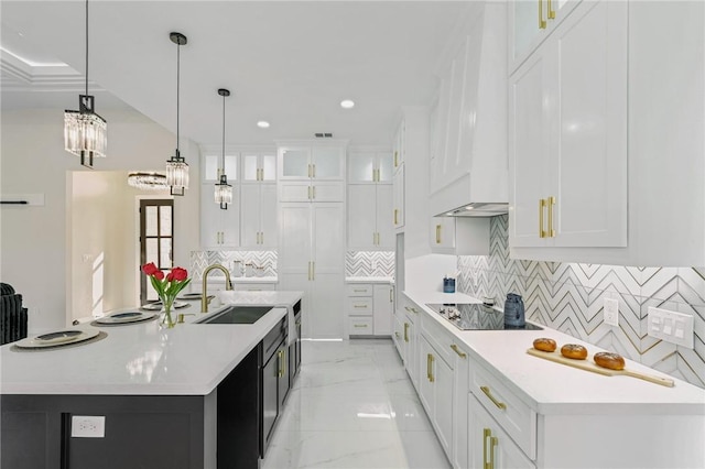 kitchen with marble finish floor, a sink, white cabinetry, light countertops, and black electric stovetop