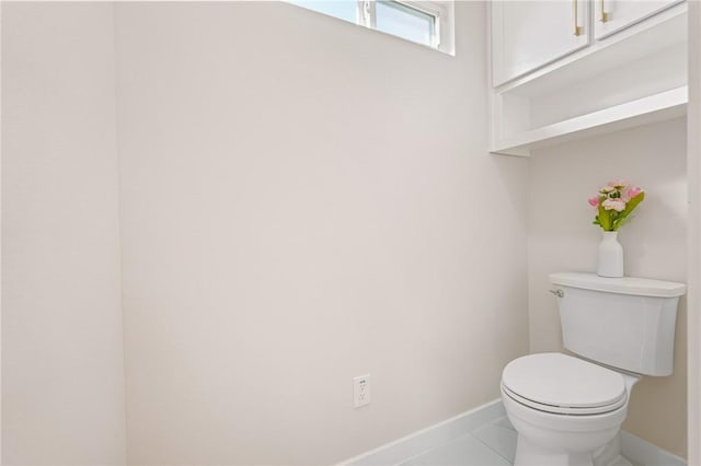 bathroom featuring tile patterned floors, baseboards, and toilet