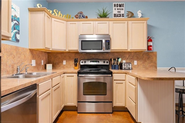 kitchen with kitchen peninsula, stainless steel appliances, tasteful backsplash, and sink