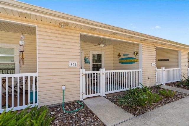 entrance to property with ceiling fan and a porch