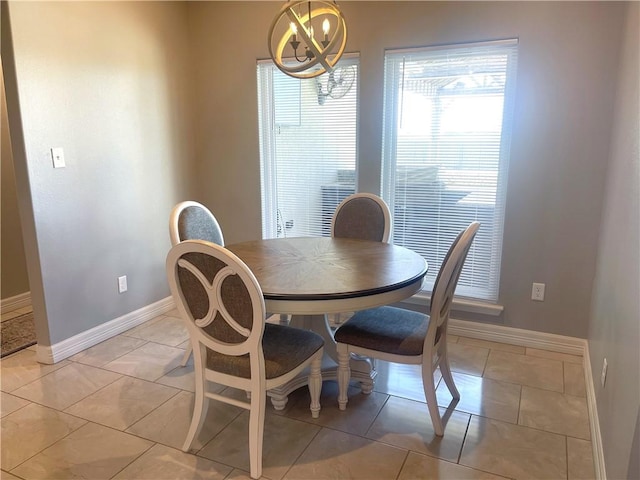 dining room with a chandelier, baseboards, and light tile patterned flooring