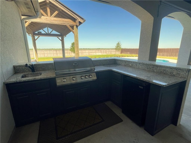 view of patio with area for grilling, a fenced backyard, a sink, a swimming pool, and a grill