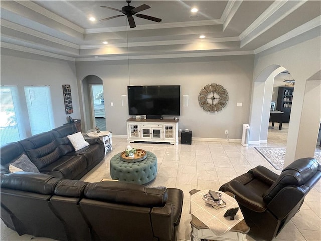 living room with a raised ceiling, crown molding, and arched walkways