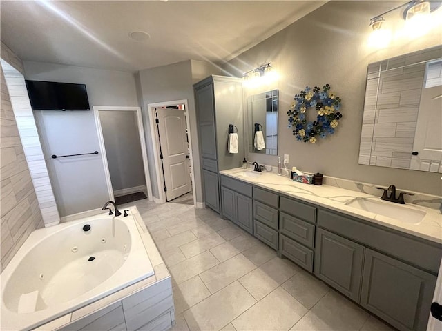 full bath featuring a sink, a tub with jets, tile patterned floors, and double vanity