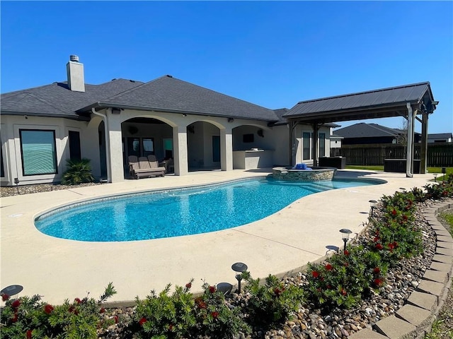 view of swimming pool featuring a patio area, exterior kitchen, fence, and a fenced in pool