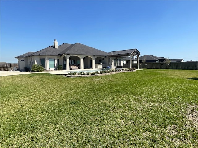 rear view of property featuring a patio, fence, a lawn, and a chimney