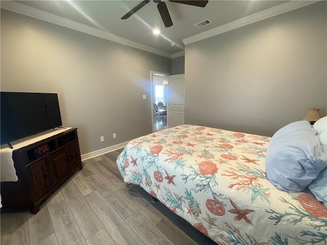 bedroom with a ceiling fan, baseboards, visible vents, crown molding, and light wood-type flooring