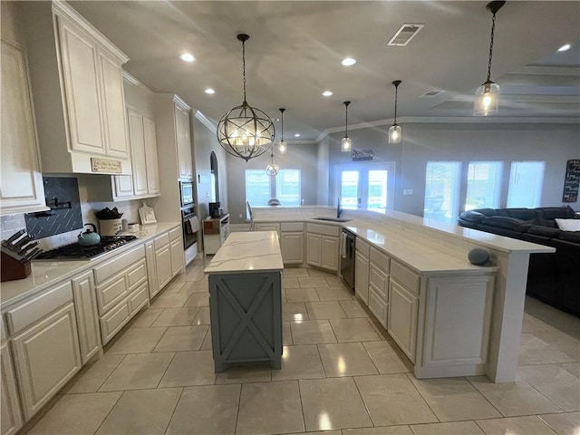 kitchen featuring visible vents, appliances with stainless steel finishes, arched walkways, a large island, and a sink