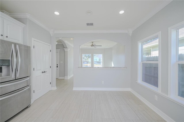 kitchen featuring white cabinetry, ornamental molding, a healthy amount of sunlight, and stainless steel refrigerator with ice dispenser