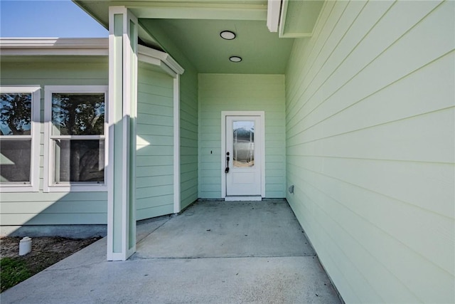 view of exterior entry featuring a patio area