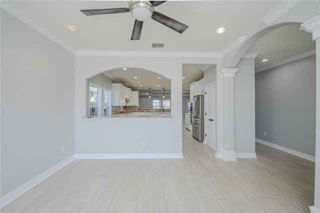 unfurnished living room featuring ornamental molding, ceiling fan, and light hardwood / wood-style flooring