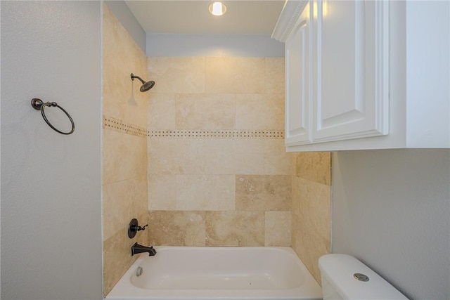 bathroom with toilet and tiled shower / bath combo