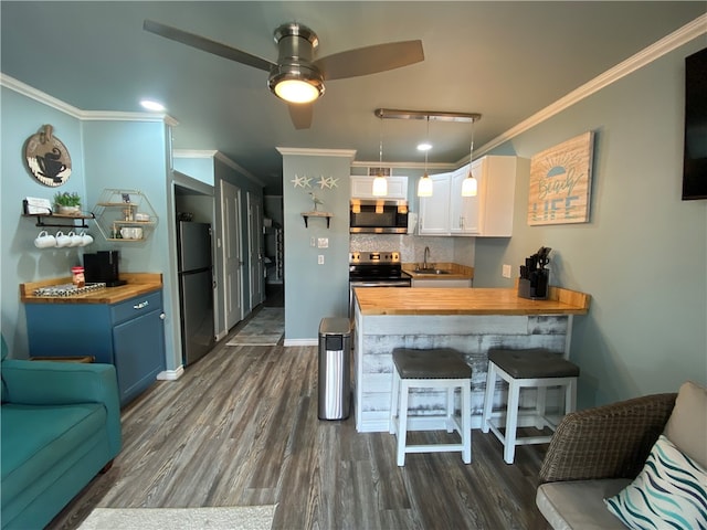 kitchen with butcher block counters, crown molding, white cabinets, and appliances with stainless steel finishes