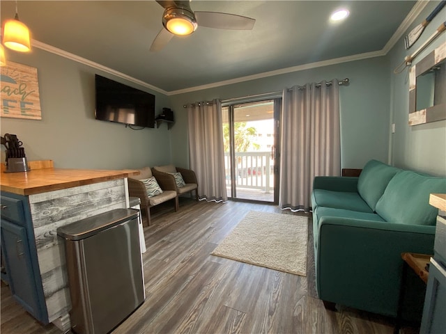 living room with ceiling fan, dark hardwood / wood-style flooring, and ornamental molding