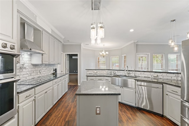 7705 Jacinto, Corpus Christi, TX 78413 - kitchen featuring stainless steel appliances, wall chimney range hood, a kitchen island, a chandelier, and backsplash