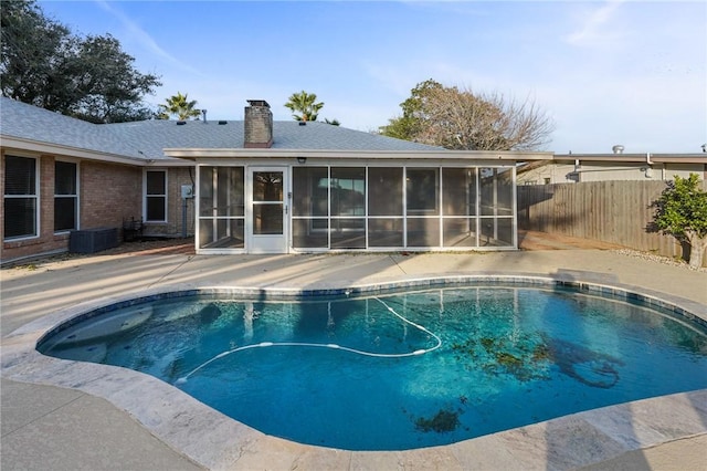 view of swimming pool featuring a sunroom and a patio