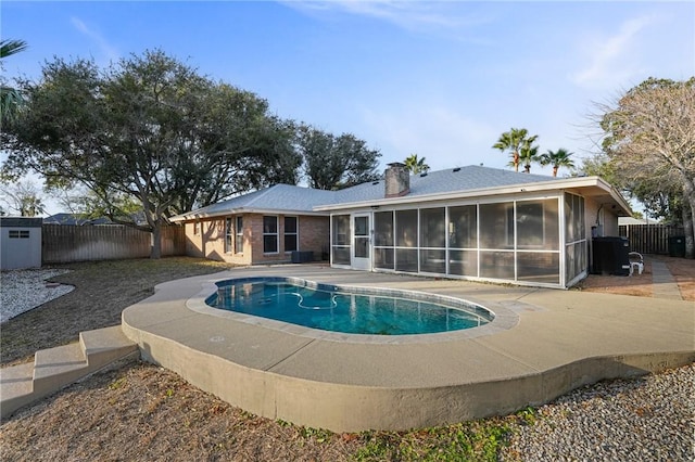 view of swimming pool featuring a sunroom and a patio