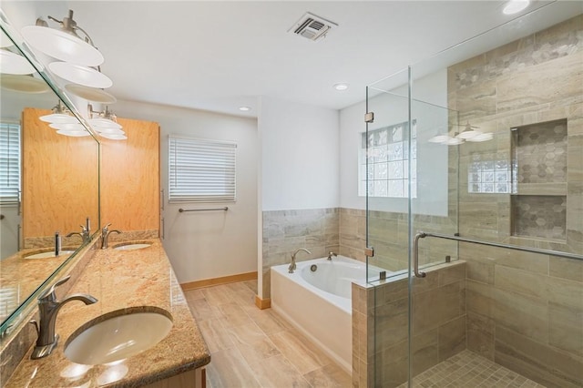 bathroom with shower with separate bathtub, plenty of natural light, and vanity