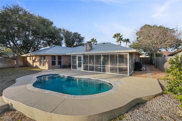 view of pool with a sunroom and a patio area