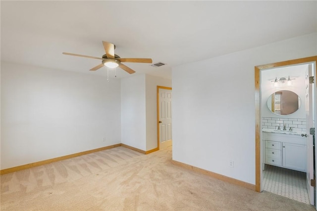 unfurnished room featuring sink, light colored carpet, and ceiling fan