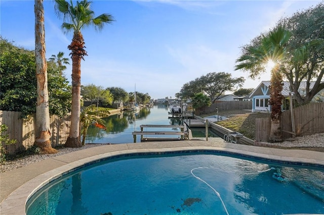 view of swimming pool featuring a water view and a boat dock