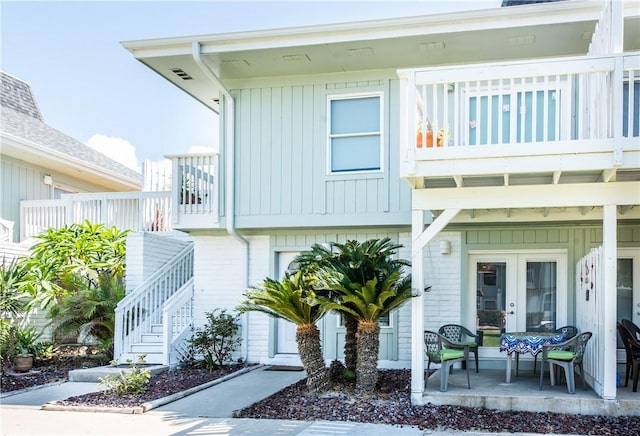 view of front of home featuring a patio area, a balcony, and french doors