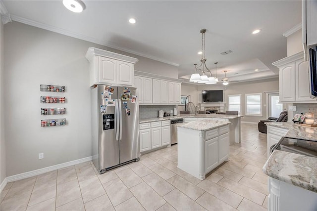 4009 Yankees Pl, Corpus Christi, TX 78414 - kitchen featuring stainless steel appliances, open floor plan, crown molding, a peninsula, and white cabinetry