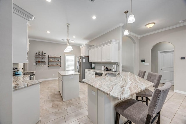 4009 Yankees Pl, Corpus Christi, TX 78414 - kitchen featuring stove, a sink, freestanding refrigerator, arched walkways, and a kitchen island
