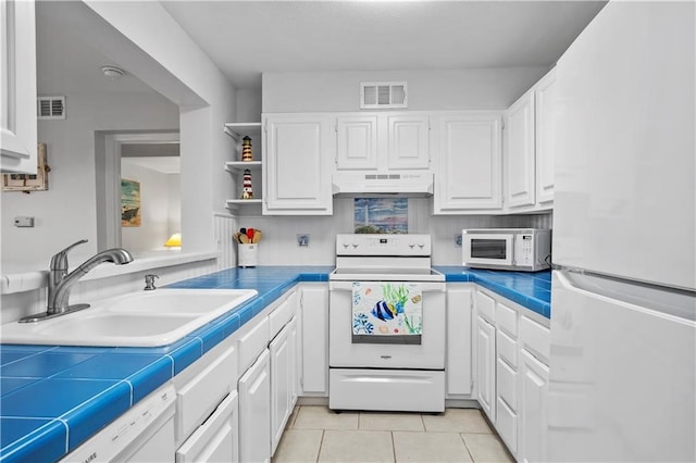 kitchen featuring white cabinets, tile countertops, and white appliances