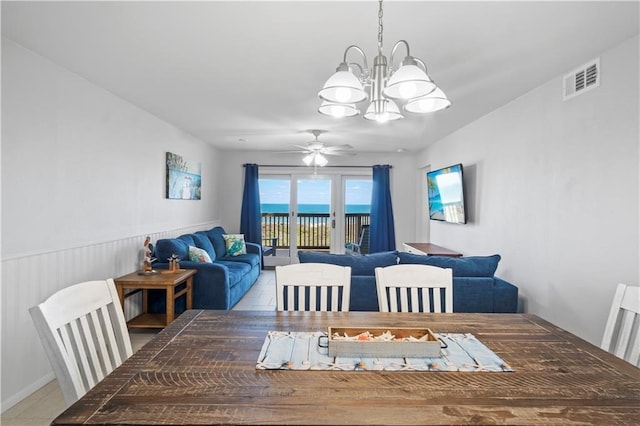 tiled dining area with ceiling fan with notable chandelier