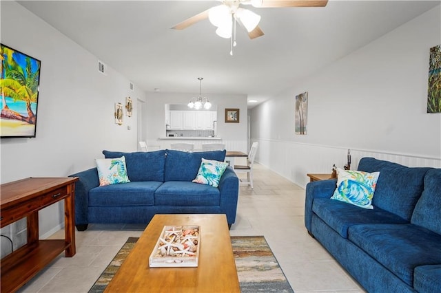 living room with ceiling fan with notable chandelier and light tile patterned floors