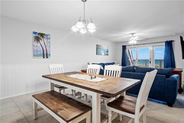 tiled dining room with ceiling fan with notable chandelier