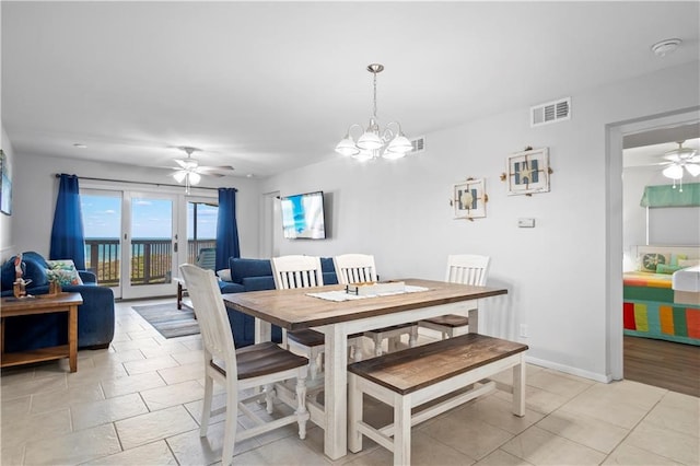 dining space with ceiling fan with notable chandelier