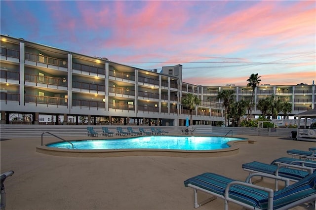 pool at dusk with a patio