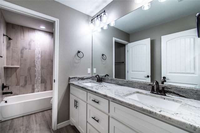 full bathroom with toilet, tiled shower / bath combo, vanity, and wood-type flooring