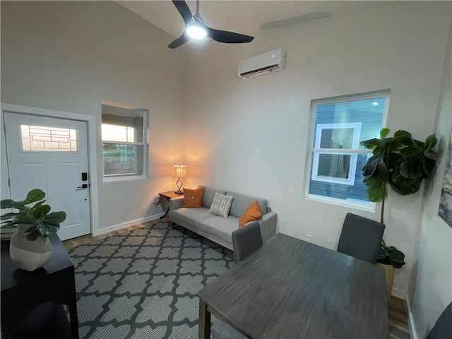 living room with dark wood-type flooring, a wall unit AC, ceiling fan, and high vaulted ceiling