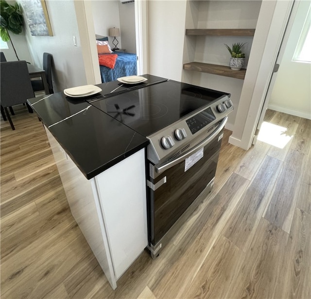 kitchen with light hardwood / wood-style flooring and electric range oven