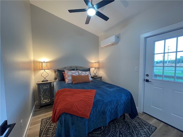 bedroom with lofted ceiling, wood-type flooring, a wall mounted air conditioner, and ceiling fan