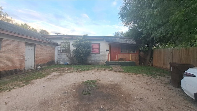 exterior space featuring brick siding and fence