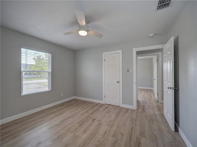 222 N 9th St, Aransas Pass, TX 78336 - unfurnished bedroom with light wood finished floors, baseboards, and ceiling fan