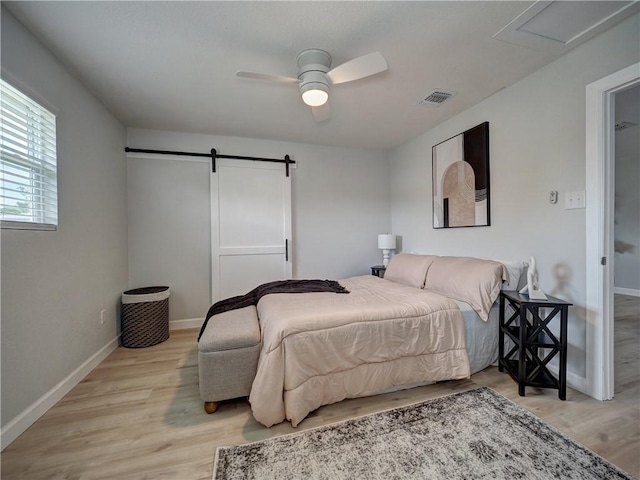 222 N 9th St, Aransas Pass, TX 78336 - bedroom featuring light wood-style flooring, baseboards, and a barn door