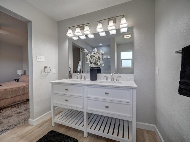 222 N 9th St, Aransas Pass, TX 78336 - full bath with wood finished floors, double vanity, baseboards, ensuite bath, and a textured wall