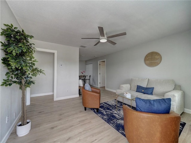 222 N 9th St, Aransas Pass, TX 78336 - living room featuring light wood-style flooring, a ceiling fan, and baseboards