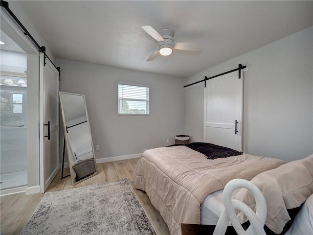 222 N 9th St, Aransas Pass, TX 78336 - bedroom with a barn door, light wood-style floors, and baseboards