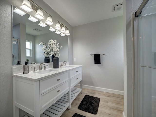 222 N 9th St, Aransas Pass, TX 78336 - full bathroom featuring wood finished floors, double vanity, and baseboards