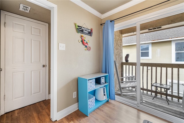 bedroom with hardwood / wood-style flooring, multiple windows, and crown molding