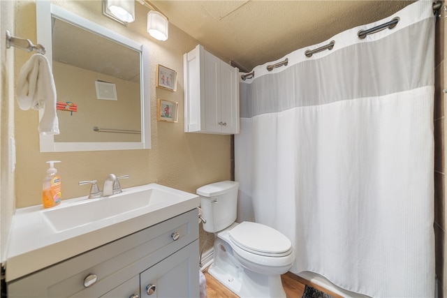 bathroom featuring a shower with shower curtain, vanity, a textured ceiling, wood-type flooring, and toilet