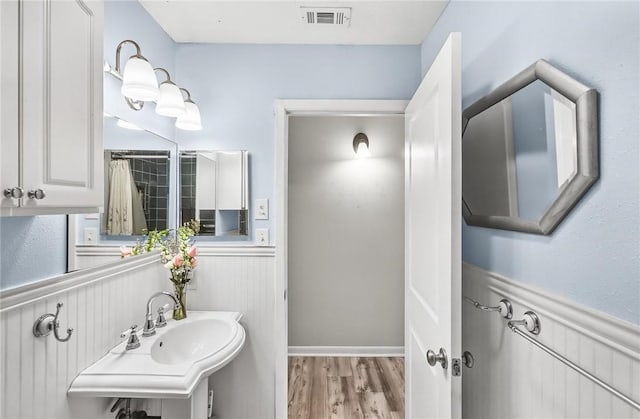 13765 Eaglesnest Bay Dr, Corpus Christi, TX 78418 - bathroom featuring a wainscoted wall and wood finished floors