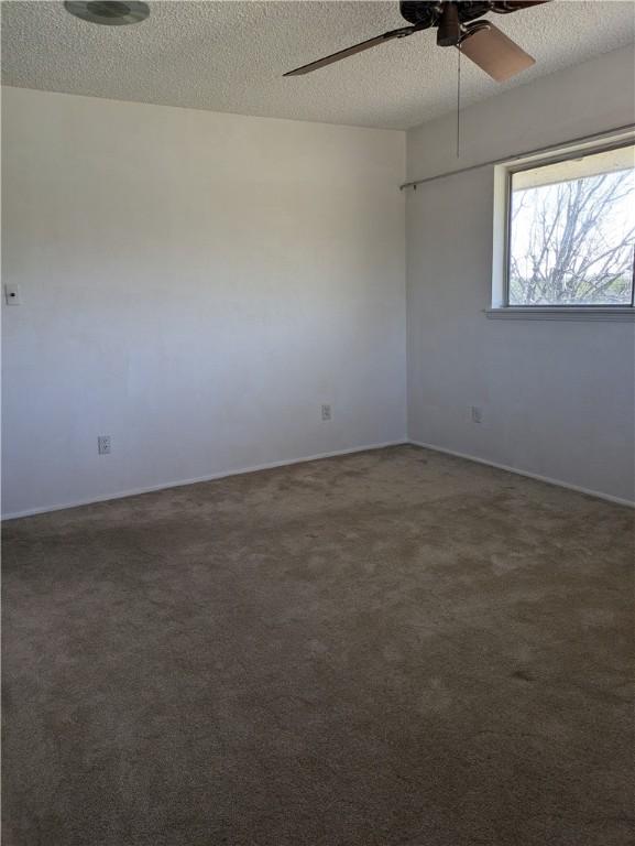 carpeted empty room with ceiling fan and a textured ceiling