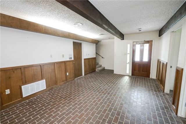 basement with wooden walls and a textured ceiling